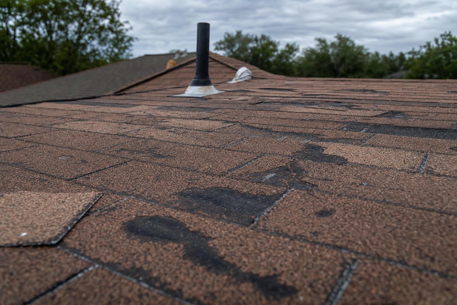 hail damage on asphalt shingles showing how long a roof lasts in Texas climate